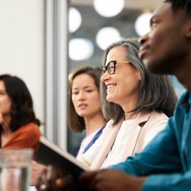 Smiling businesswoman looking away with colleagues